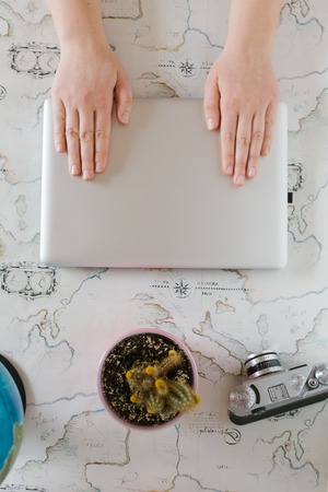 Woman typing on a computer and writing a noteの写真素材