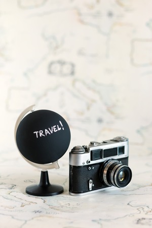 Camera and globe with travel letters on itの写真素材
