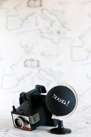 Camera and globe with travel letters on itの写真素材