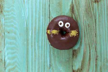 Donut with sprinkles on wooden backgroundの写真素材