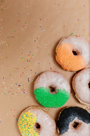 Sweet sugary donuts on crumpled baking paper, top view of tasty bakery doughnuts in vintage retro toned overhead shotの写真素材