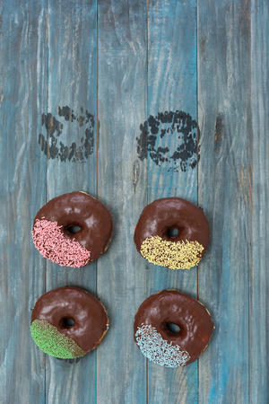 Hand decorated artisan donuts on wooden rustic table, from aboveの写真素材