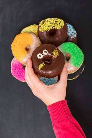 female  hand reaching to grab the doughnutの写真素材