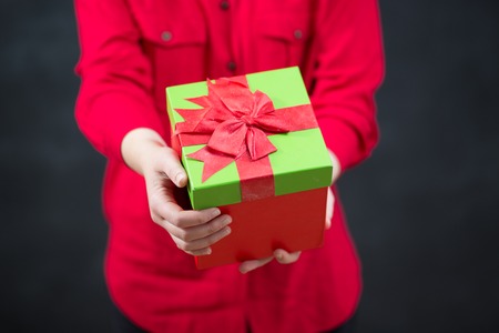 Female hands holding gift with ribbon.の写真素材