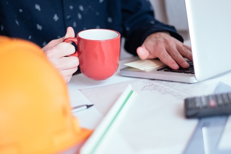 Cropped image of male architect using laptop in officeの写真素材