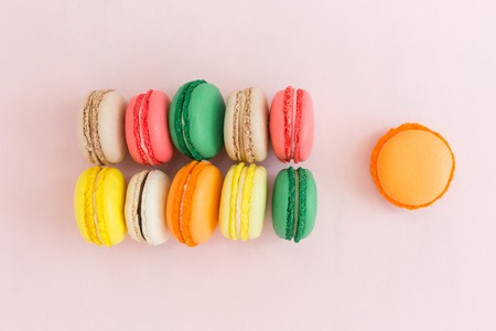 Sweet colorful French macaroon biscuits on pastel background, top viewの写真素材