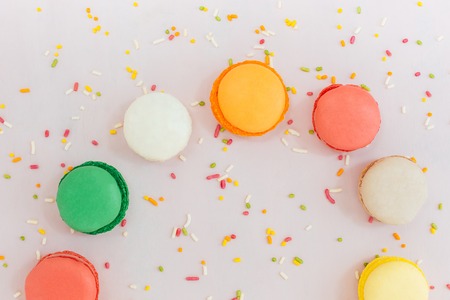 Sweet colorful French macaroon biscuits on pastel background, top viewの写真素材