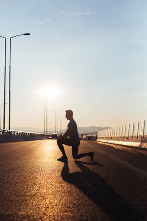 Male runner silhouette, Man running into sunset, colorful sunset sky, streching on sunset