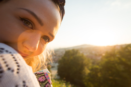 portrait of young beautiful girl is watching susnet in summer environmentの写真素材
