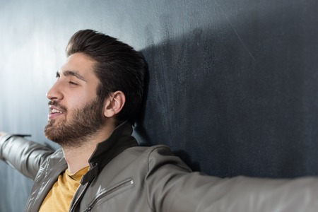 Portrait of masculinity. Portrait of handsome young bearded manstanding against grey backgroundの写真素材