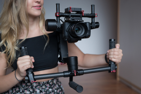 woman videographer with gimball video slrの写真素材