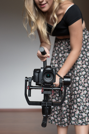 Professional  woman videographer with gimball video slrの写真素材