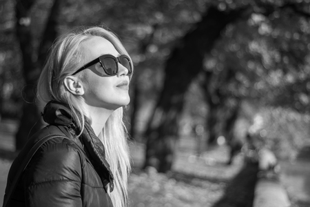 Close-up lifestyle image of sensual woman,natural beauty,no cosmetics,long hairs,wavy hair,teen suit clothes and accessories,positive playful emotions,joy,sunglasses fashion,toned,glowing skin toneの写真素材