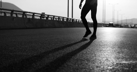 Running at sunrise man exercising for marathon and workout fitnessの写真素材