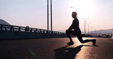 Running at sunrise man exercising for marathon and workout fitnessの写真素材