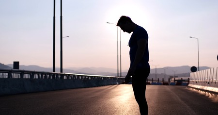 Running at sunrise man exercising for marathon and workout fitnessの写真素材