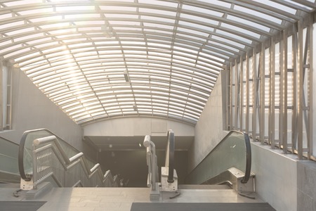 Wide angled view to perspective escalators stairway inside contemporary blue glass business centre, concept of successful career elevationの写真素材
