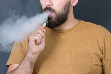 close up portrait of a man smoking an e-cigaretteの写真素材
