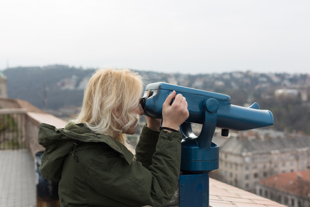 Woman seeing the city over a river through binocular.の写真素材