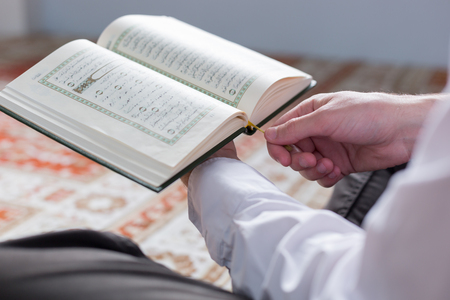Koran in hand - holy book of Muslims ( public item of all muslims )の写真素材