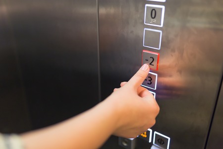 Pushing button. Close-up of female hand pushing button of elevatorの写真素材