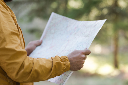 bearded man with a map in hand looking awayの写真素材