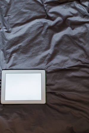 White tablet on the bed on a bed - mockupの写真素材