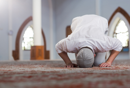 Religious muslim man praying inside the mosque