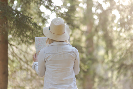 traveler girl searching right direction on map, bright orange sunset light, traveling along Europe, freedom and active lifestyle conceptの写真素材