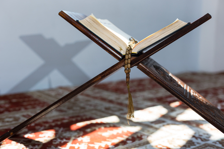 Holy Quran with beads over wooden background closeup. Small shallow DOF.の写真素材