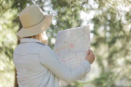 traveler girl searching right direction on map, bright orange sunset light, traveling along Europe, freedom and active lifestyle conceptの写真素材