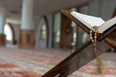 Holy Quran with beads over wooden background closeup. Small shallow DOF.の写真素材