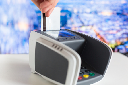 Credit card in hand and terminal in shopの写真素材