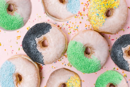 Stack of assorted donuts on a pink backgroundの写真素材