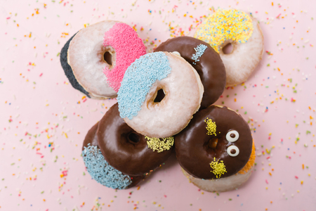 Stack of assorted donuts on a pink backgroundの写真素材
