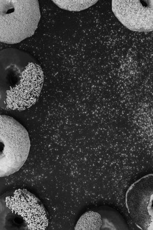 Assorted donuts with powder flour on black backgroundの写真素材