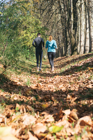 Trail running marathon athlete outdoors sunrise couple training for fitness and healthy lifestyleの写真素材
