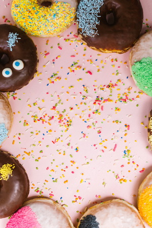 Stack of assorted donuts on a pink backgroundの写真素材