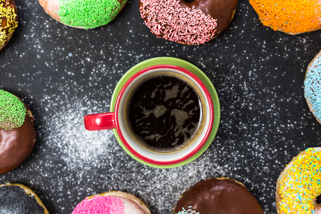 Assorted donuts with coffee and powder flour on black backgroundの写真素材