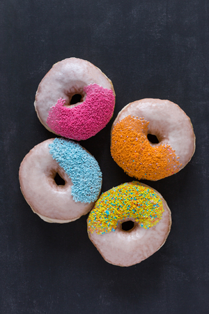 Assorted donuts with powder flour on black backgroundの写真素材