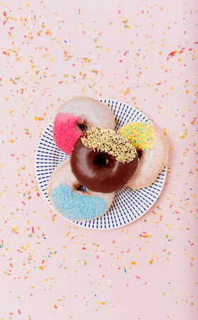 Stack of assorted donuts on a pink backgroundの写真素材