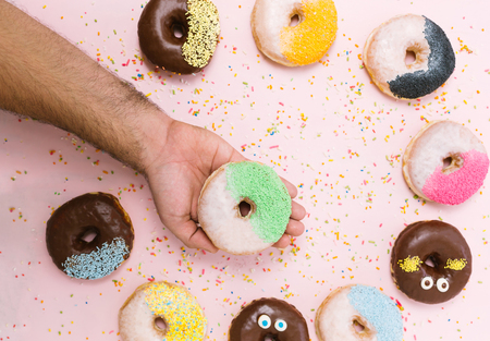 people, food, junk-food and eating concept - close up of female hand holding glazed donutの写真素材
