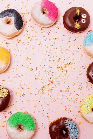 Stack of assorted donuts on a pink backgroundの写真素材