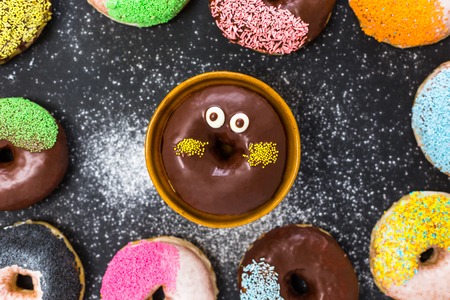 Assorted donuts with coffee and powder flour on black backgroundの写真素材