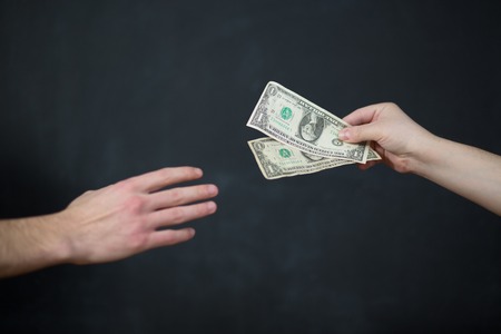 Concept - corruption. Giving a bribe. Money in handの写真素材