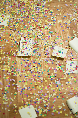 colorful confetti and streamer lying on floor in fron of backgroundの写真素材
