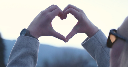 Beautiful caucasian blonde woman  showing heart sign with fingers, valentine day concept
loveの写真素材