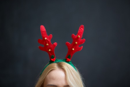 Happy smiling young woman wearing Christmas deer horns. Christmas party. Beauty, fashion.の写真素材