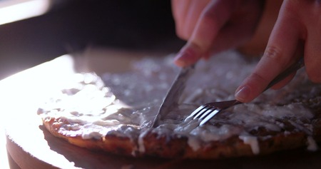 Cutting the pie with sour cream over it while food is still smokingの写真素材