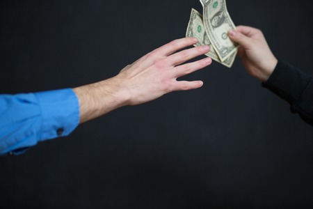 Concept - corruption. Giving a bribe. Money in handの写真素材